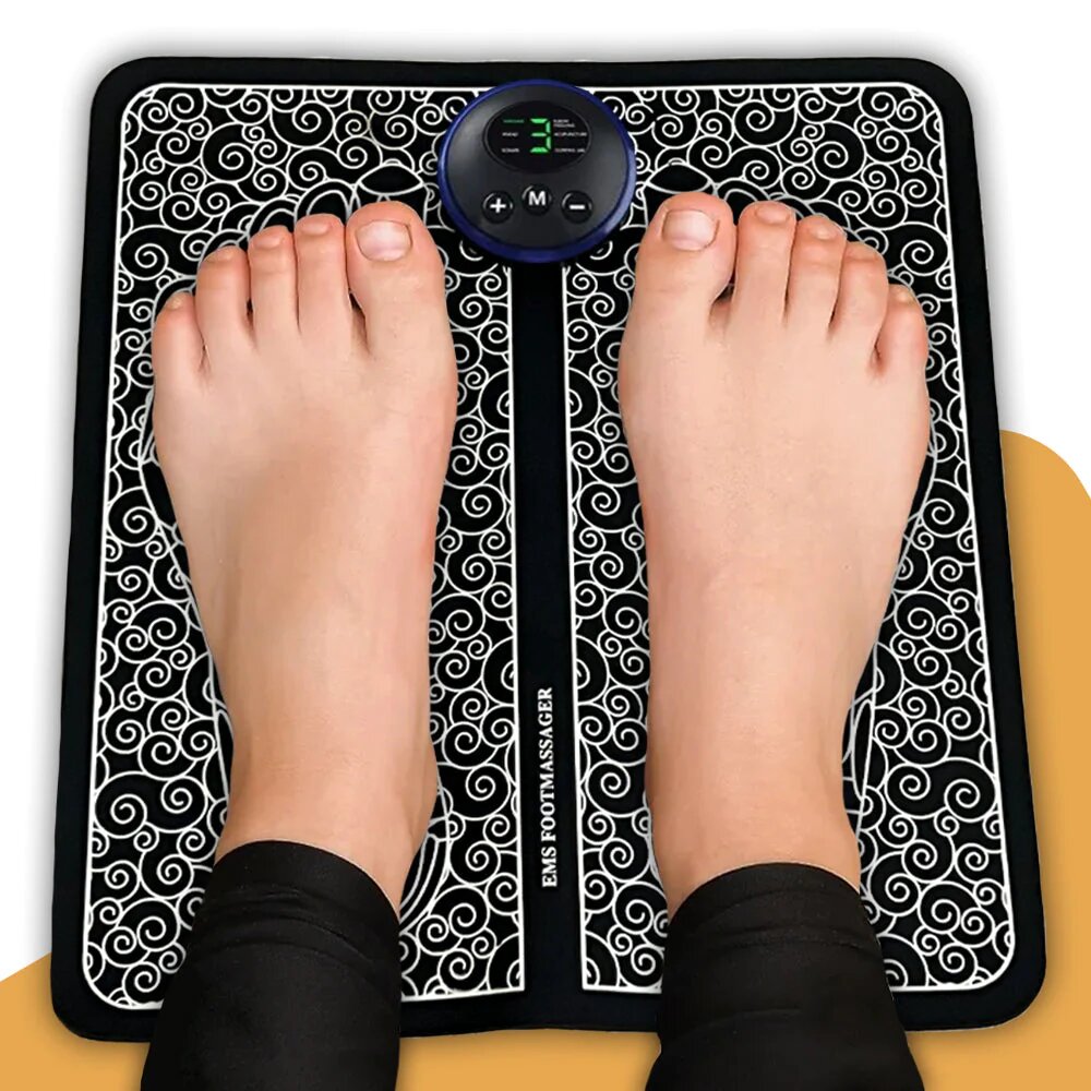 Person using a foot massager with digital display on a decorative mat.